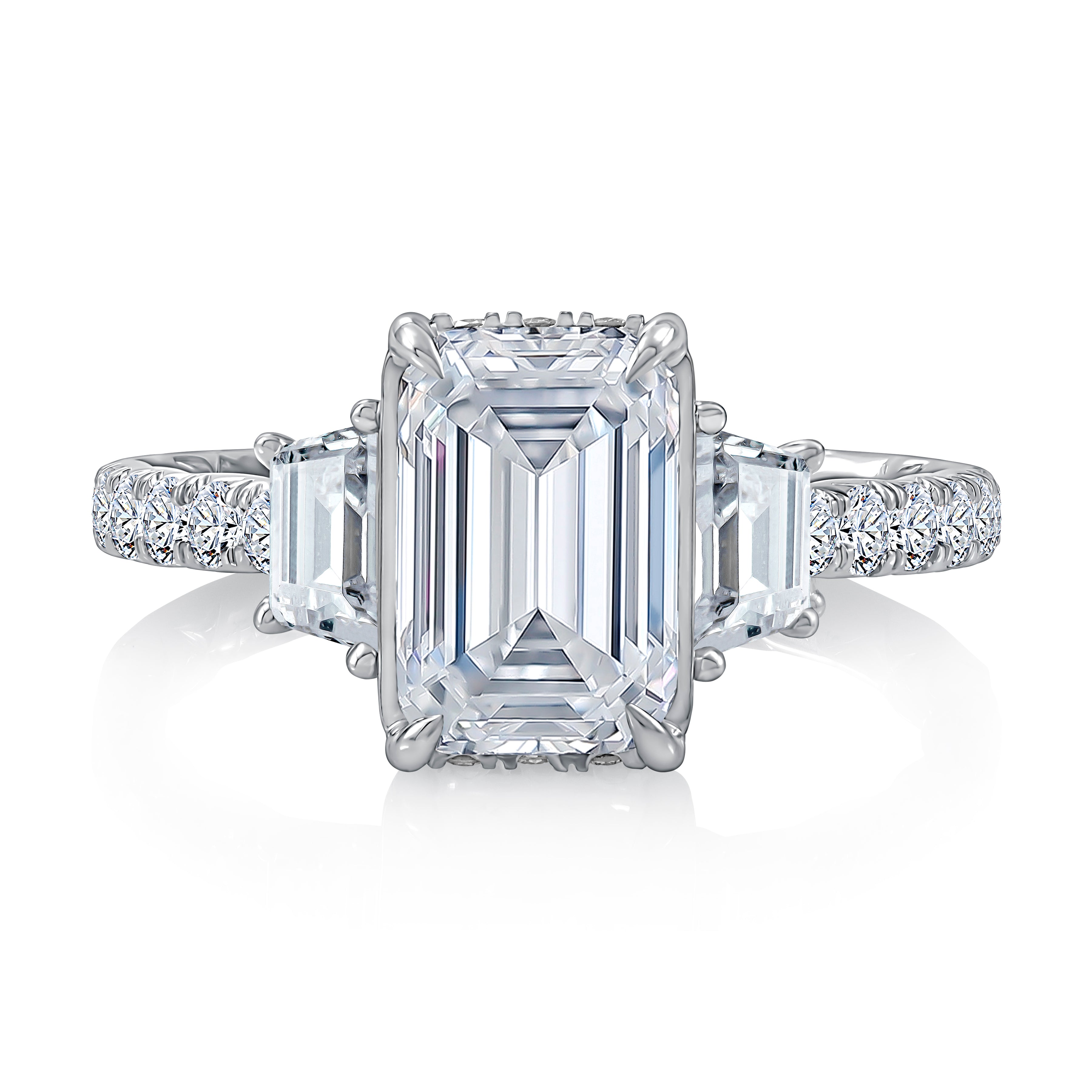 Top view of a 14K white gold three-stone engagement ring with an emerald-cut center diamond