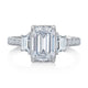 Top view of a 14K white gold three-stone engagement ring with an emerald-cut center diamond
