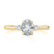 Top view of a 14K yellow gold three-stone engagement ring with an oval center diamond