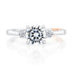 Top view of a 14K white gold three-stone engagement ring with a round center diamond